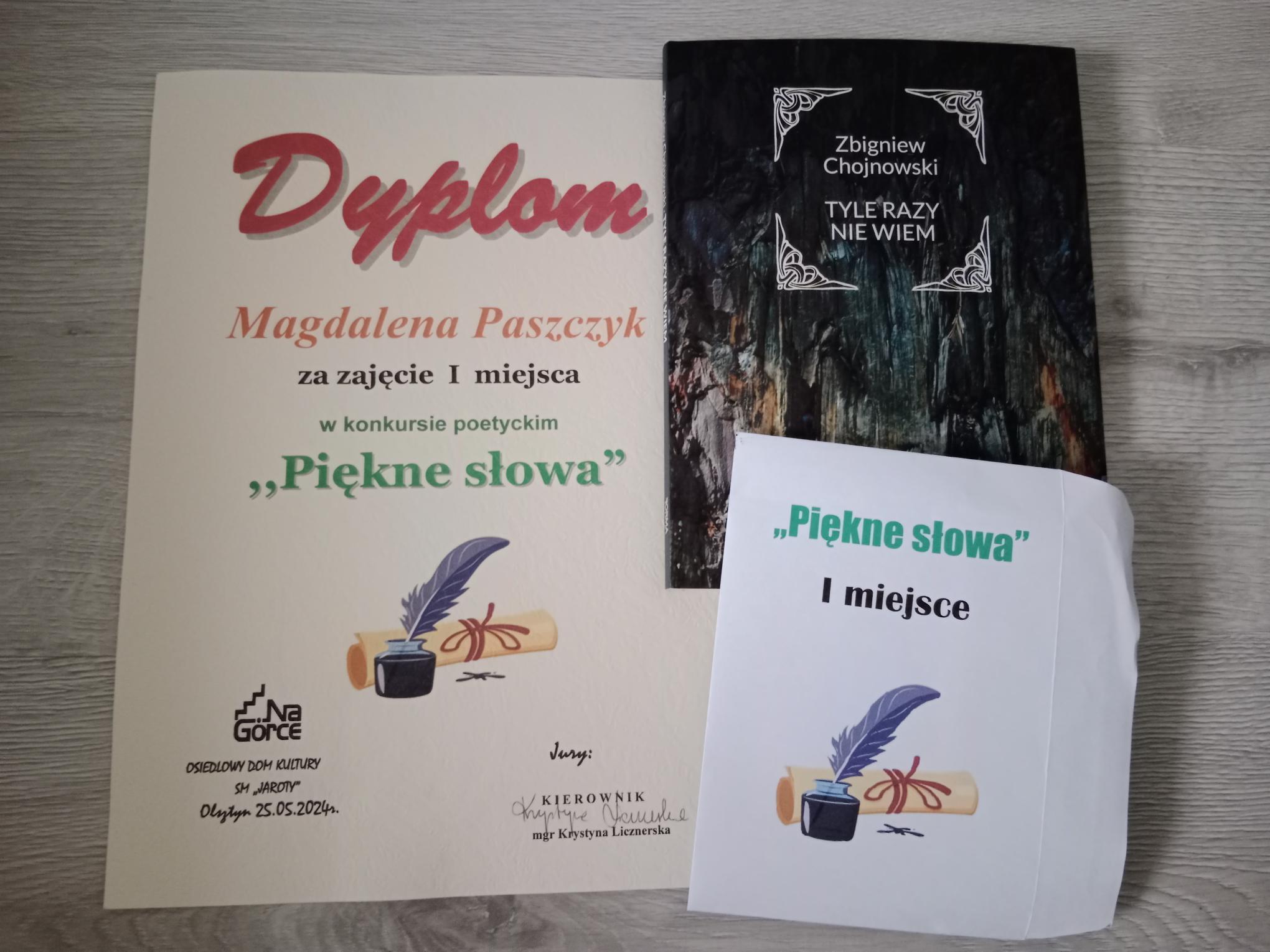 Zdjęcie przedstawia dyplom, który otrzymała Magdalena za udział w konkursie „Piękne słowa” oraz książkę pana Zbigniewa Chojnowskiego będącą prezentem dla uczennicy.