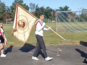 Uczeń niesie sztandar szkoły