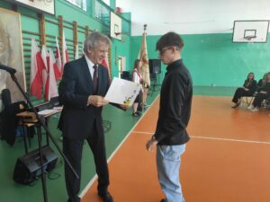 Dyrektor wręcza świadectwo uczniowi