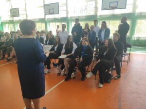 Wychowawca na sali gimnastycznej sprawdza obecność swojej klasy