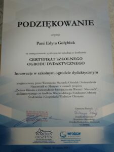 Przedstawia podziękowanie dla osoby realizującej projekt, na którym widnieją słowa: Podziękowanie otrzymuje Pani Edyta Gołębiak za zaangażowanie społeczności szkolnej w konkursie CERTYFIKAT SZKOLNEGO OGRODU DYDAKTYCZNEGO Innowacje w szkolnym ogrodzie dydaktycznym zorganizowany przez Warmińsko – Mazurski Ośrodek Doskonalenia Nauczycieli w Olsztynie w ramach projektu „Zmiana klimatu a różnorodność biologiczna na Warmii i Mazurach, dofinansowanego ze środków Wojewódzkiego Funduszu Ochrony Środowiska i Gospodarki Wodnej w Olsztynie. Na dyplomie złożono podpisy organizatorów.