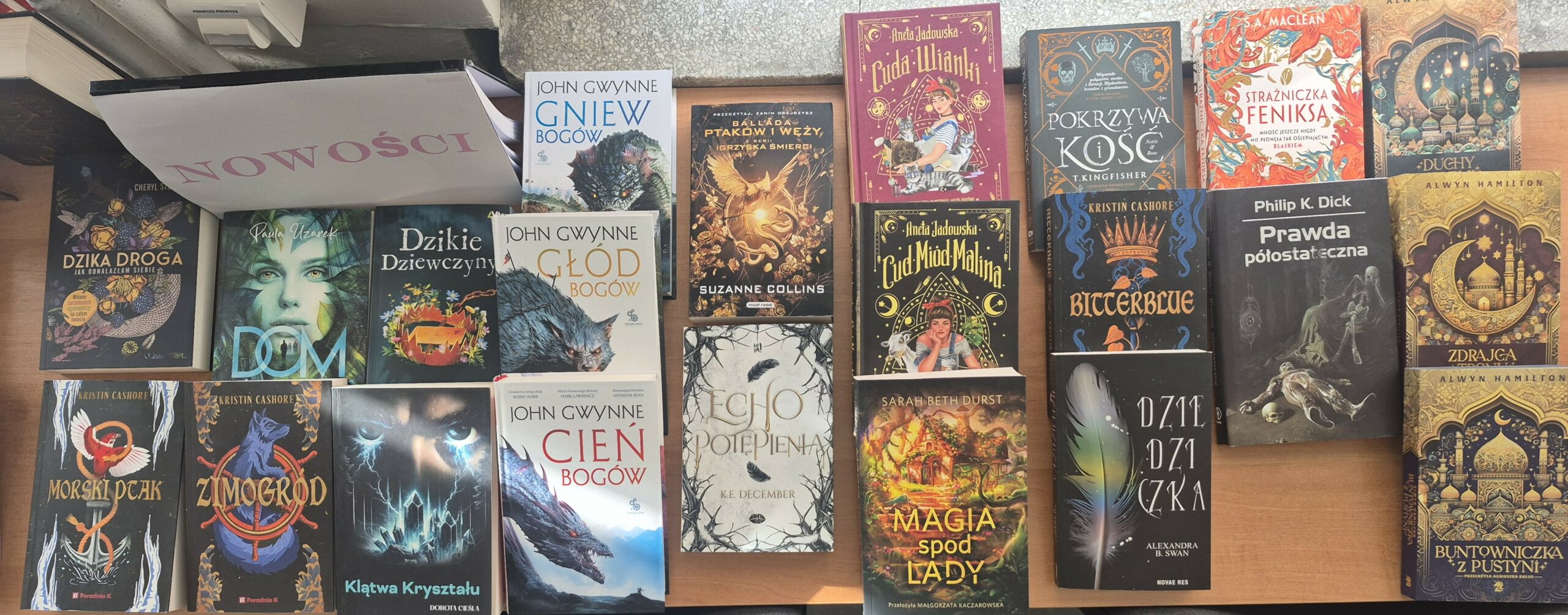 Zdjęcie przedstawia książki z gatunku fantastyka, między innymi: „Zimogród”, „Morski ptak”, „Klątwa kryształu”, „Magia spod lady”, „Dziedziczka”, „Prawda półostateczna”.