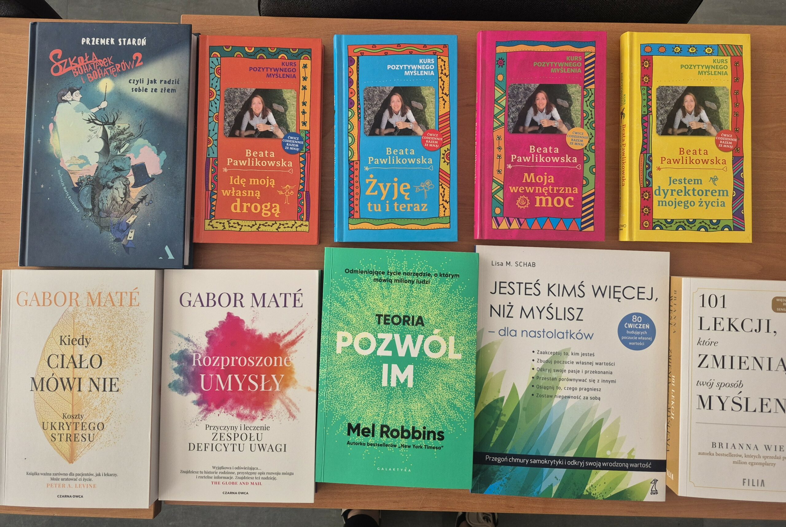 Zdjęcie przedstawia książki psychologiczne, pedagogiczne oraz poradniki, takie jak: „Kiedy ciało mówi nie”, „Rozproszone umysły”, „Szkoła bohaterek i bohaterów 2, czyli jak radzić sobie ze złem”, „Idę moją własną drogą”, „Żyję tu i teraz”, „101 lekcji, które zmienia twój sposób myślenia”.