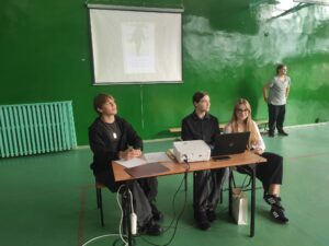 Uczniowie wyświetlający zdjęcia nauczycieli do konkursu