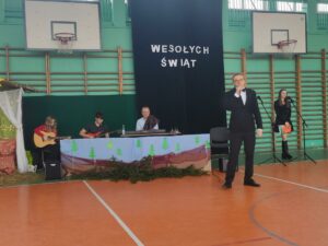 Widok zespołu muzycznego oraz osoby śpiewającej kolędy