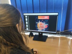 Zdjęcie uczennicy przeglądającej na komputerze materiały na temat zagrożeń internetowych.